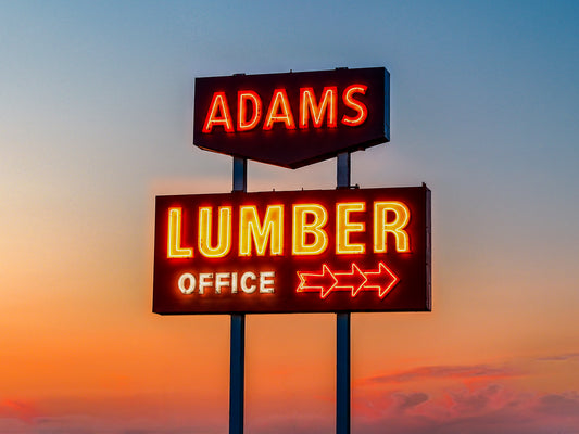 Restored Adams Lumber neon sign glowing at sunset in Saskatoon, Saskatchewan